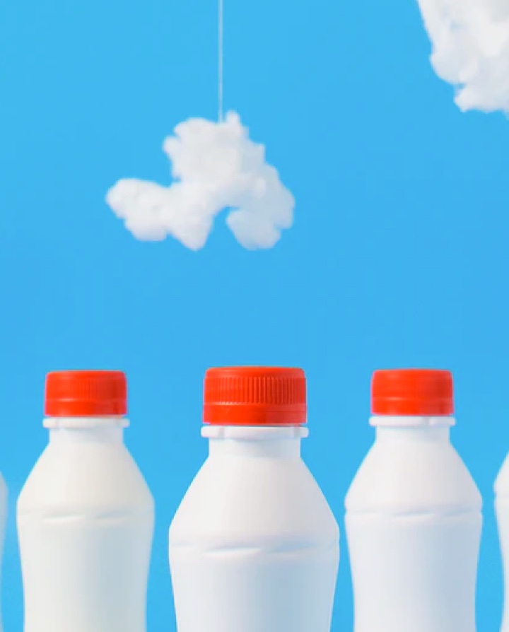 Three milkbottles in front of sky backdrop